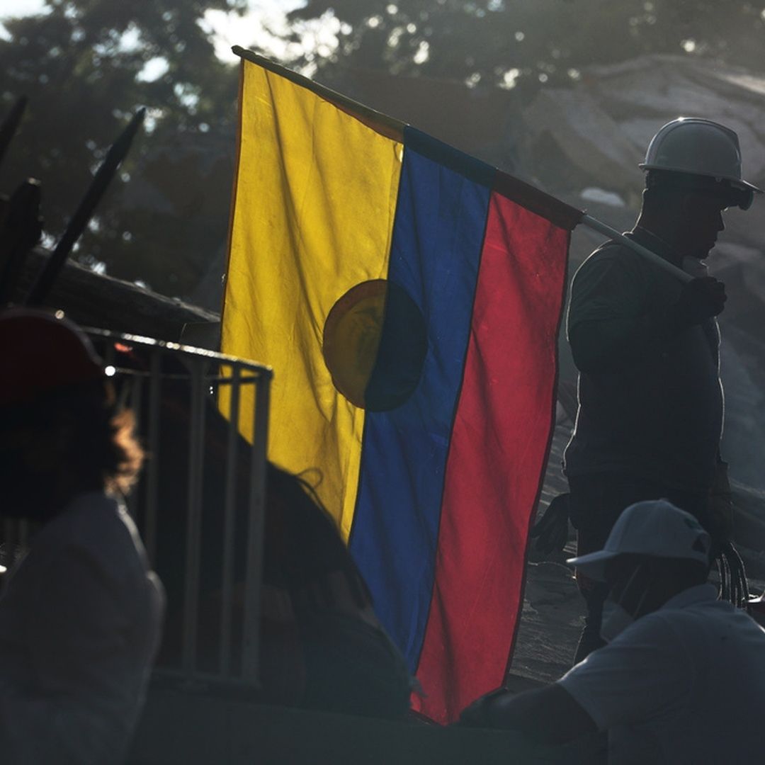 Un bombero sostiene una bandera de Colombia durante las labores de rescate entre los escombros, tres días después del terremoto en Cali.